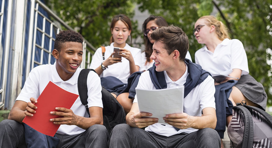 Students in uniforms with homework